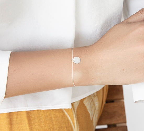 Armband mit einer Silbermedaille am Kettenfaden - Detailansicht